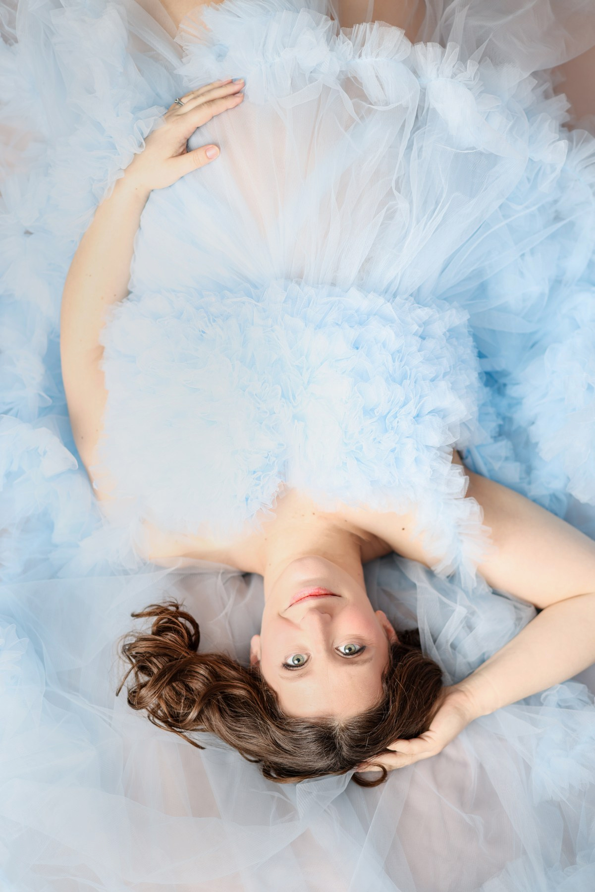 Overhead maternity portrait with flowing pale blue tulle
